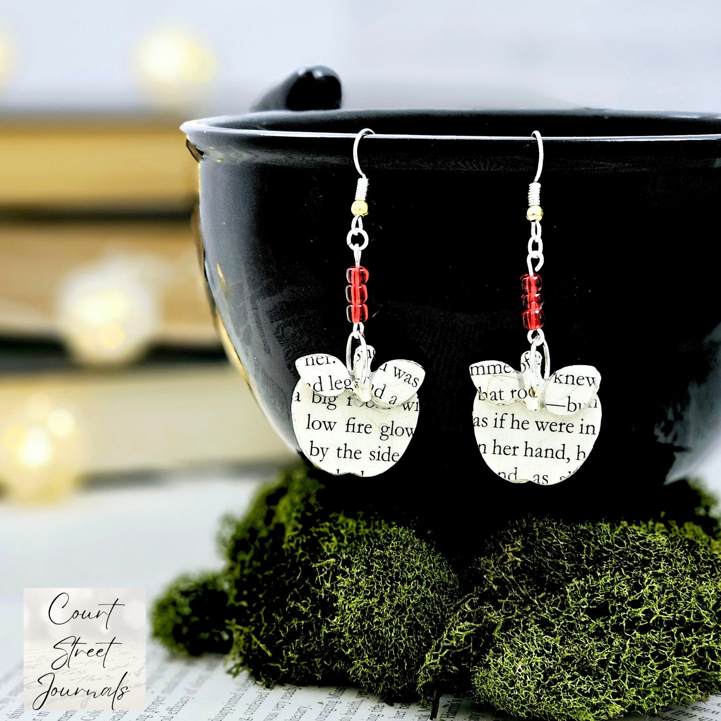 Apple Dangle Earrings made from upcycled book pages. The top of the earring has 3 red glass seed beads.