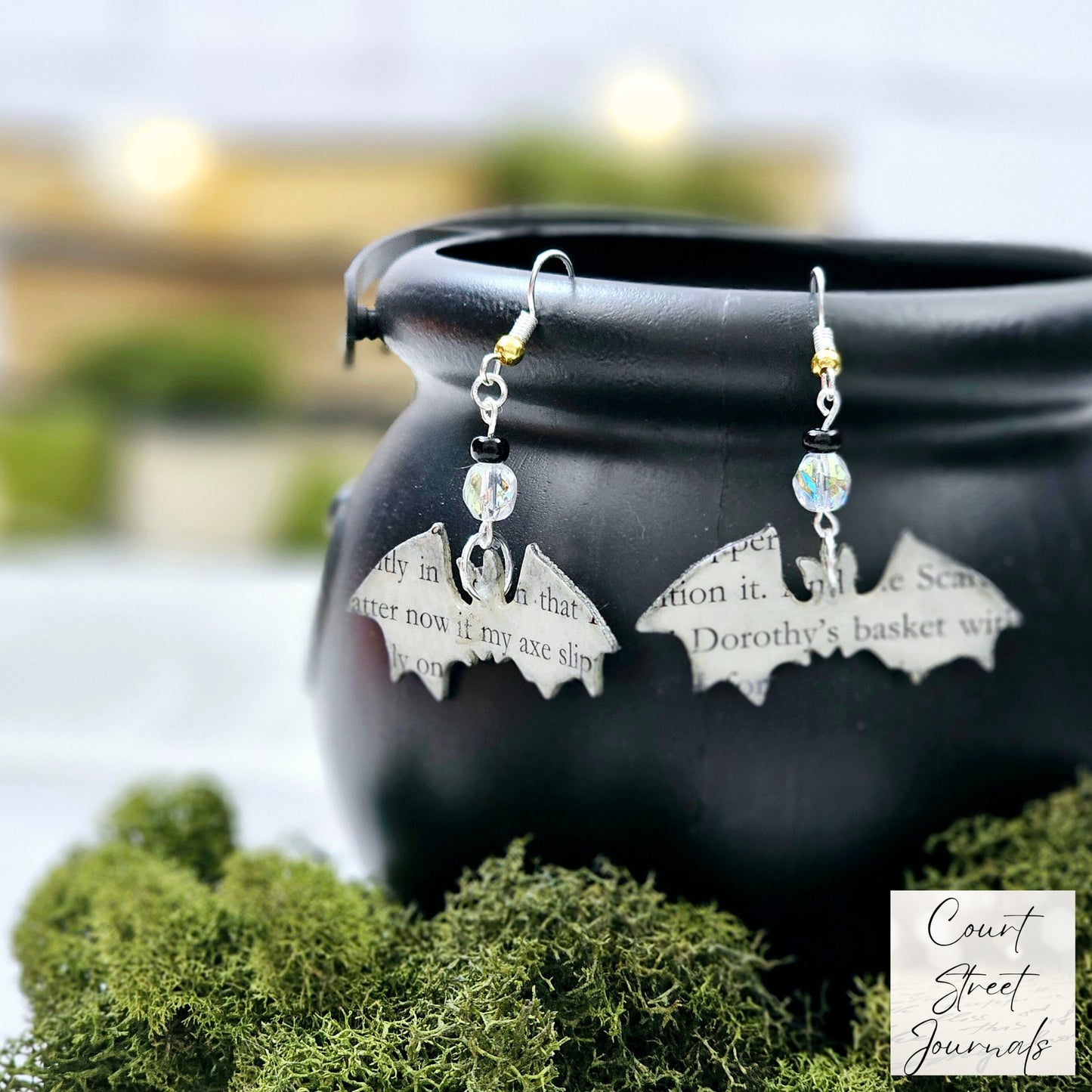 Bat shaped earrings made from book pages. Dangle ear wire.