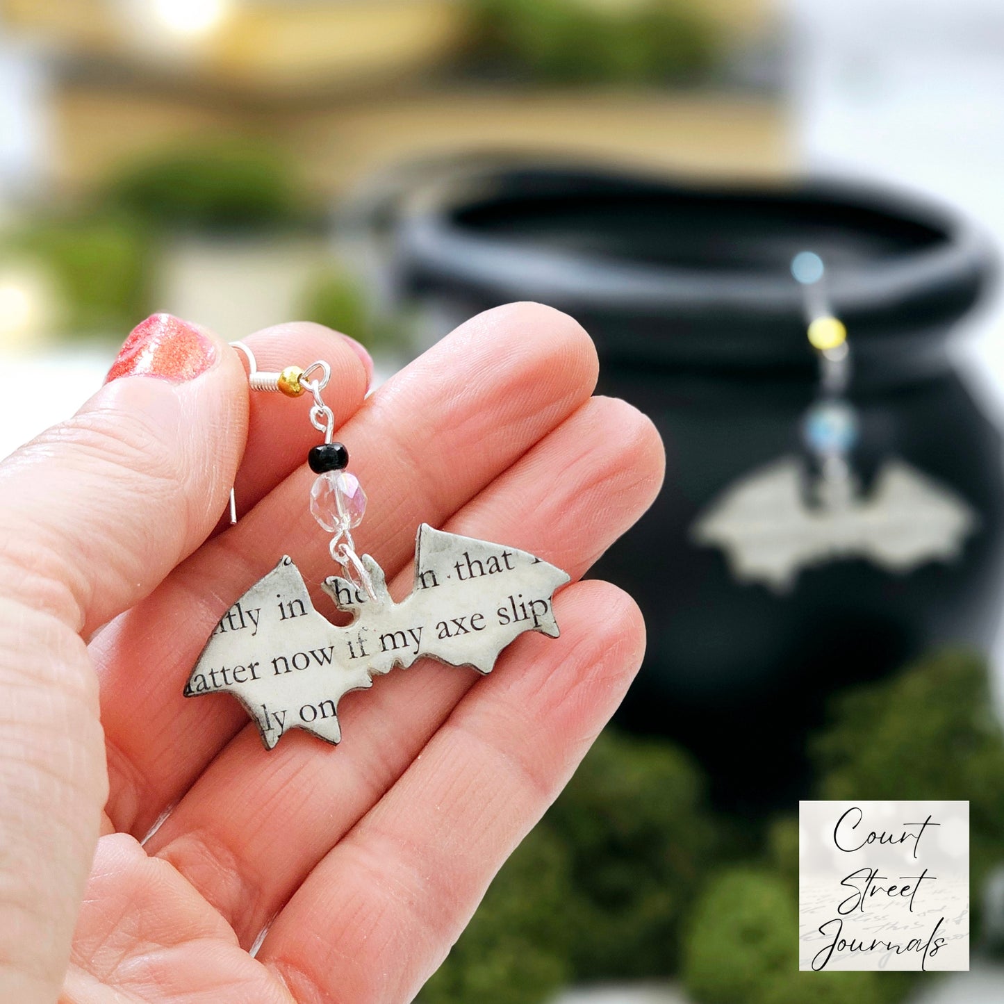 close up of bat book page earrings