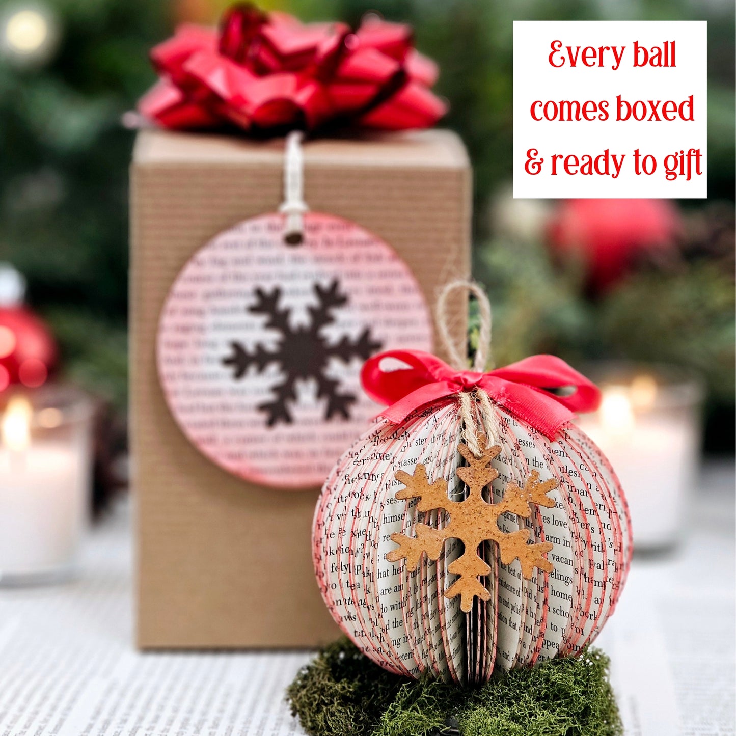 Round ball book page ornament made from book pages. It has a jute string for hanging, a red bow on the top and a rustic metal snowflake on the front. It comes in a gift box with a bow and a gift tag made from a book page.