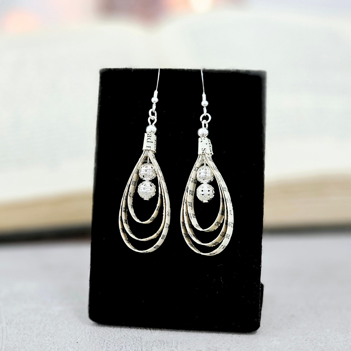 Tear drop shaped book page ornaments. Made from upcyceld book pages taken from literary classes. Sterling Silver Ear wire. Center of tear drop has two silver plated beads.