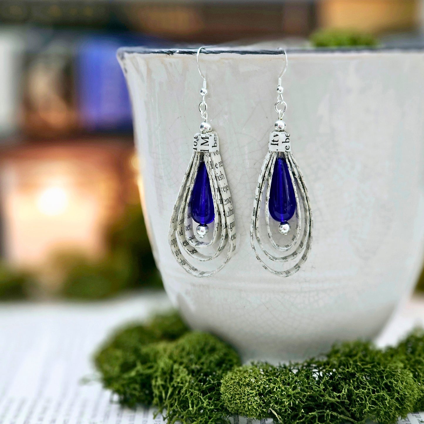 Tear Drop dangle earrings made from upcycled book pages with a blue czech glass tear drop bead accent. earring is 2.5 inches long. Sterling silver ear wire.