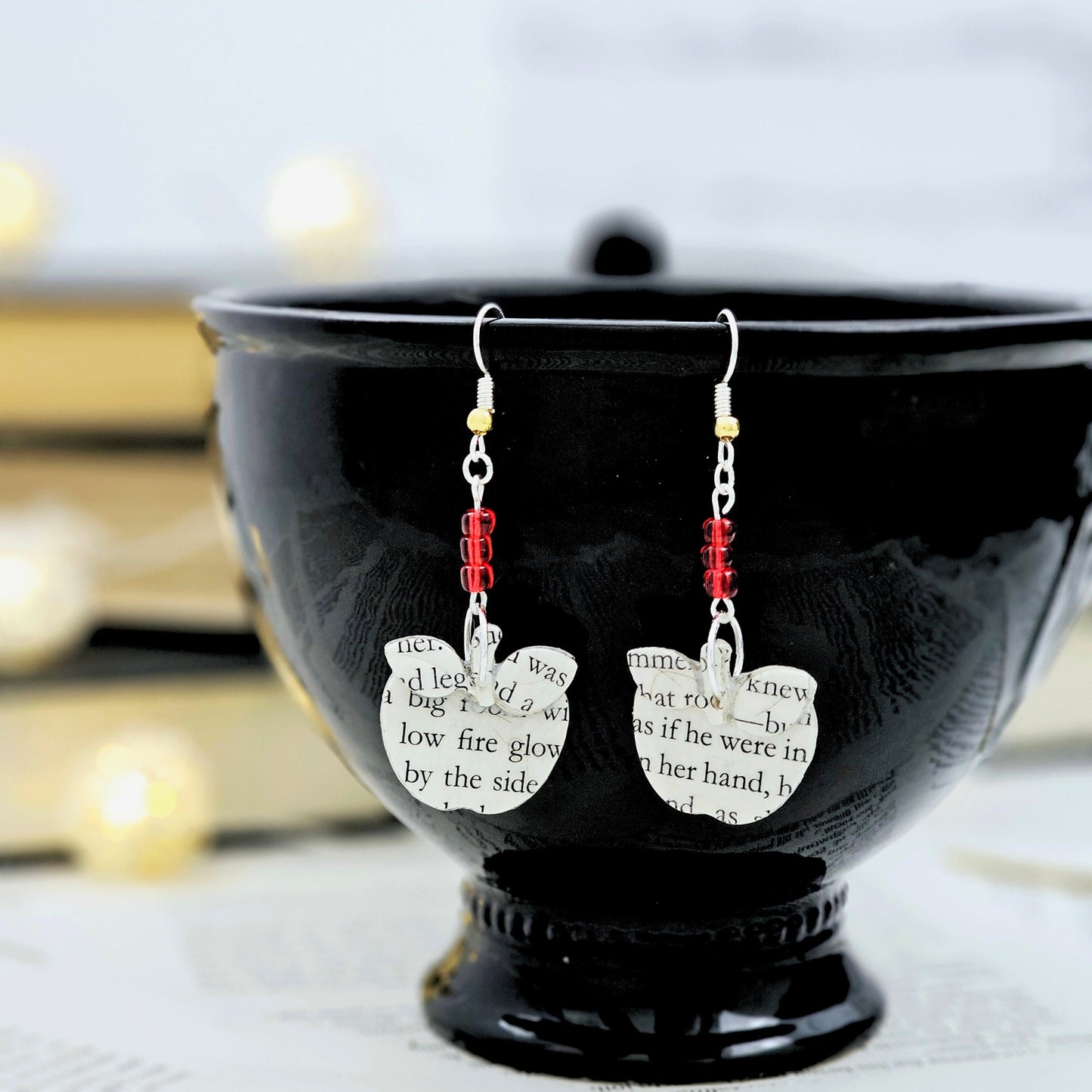 Apple Dangle Earrings made from upcycled book pages. The top of the earring has 3 red glass seed beads.