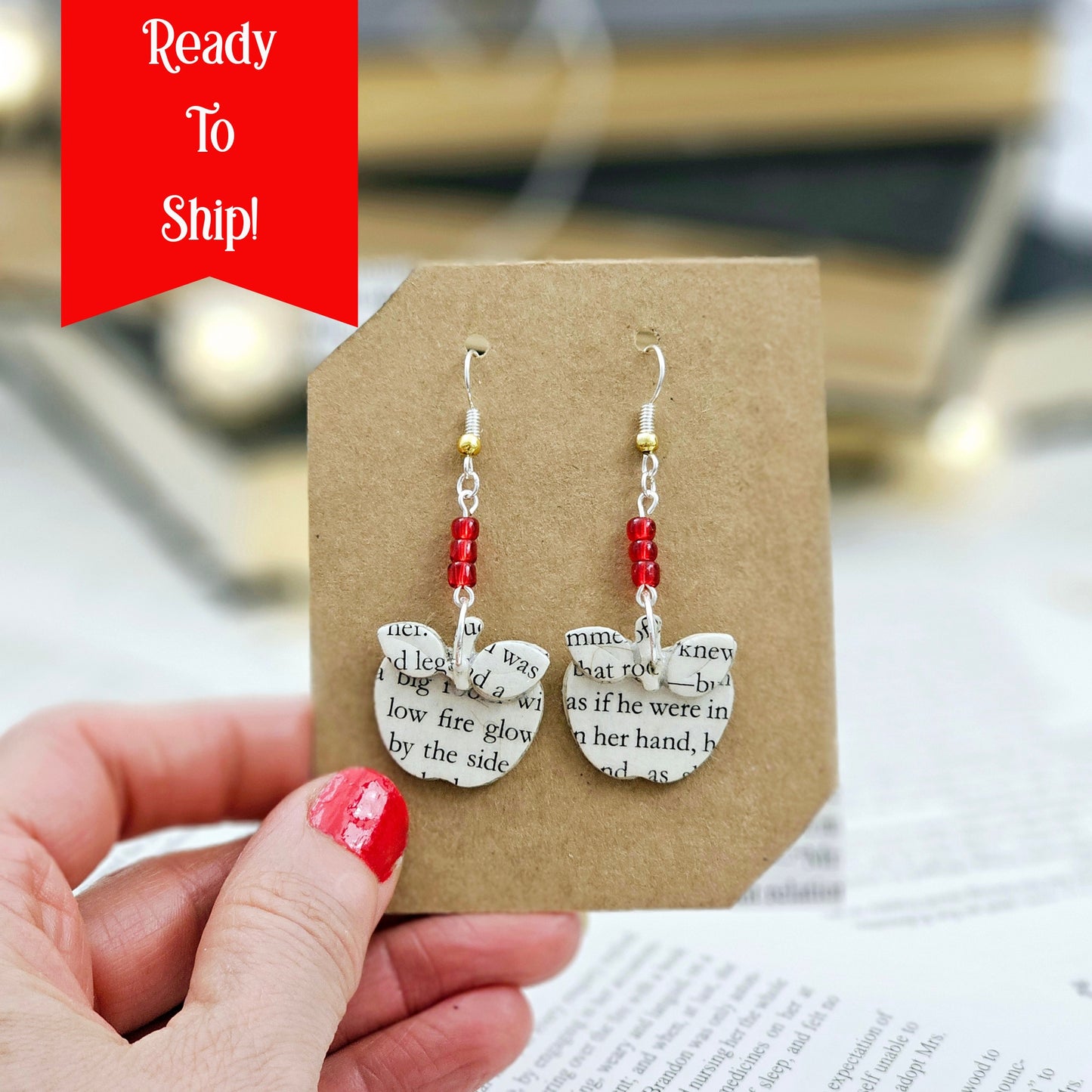 Apple Dangle Earrings made from upcycled book pages. The top of the earring has 3 red glass seed beads.