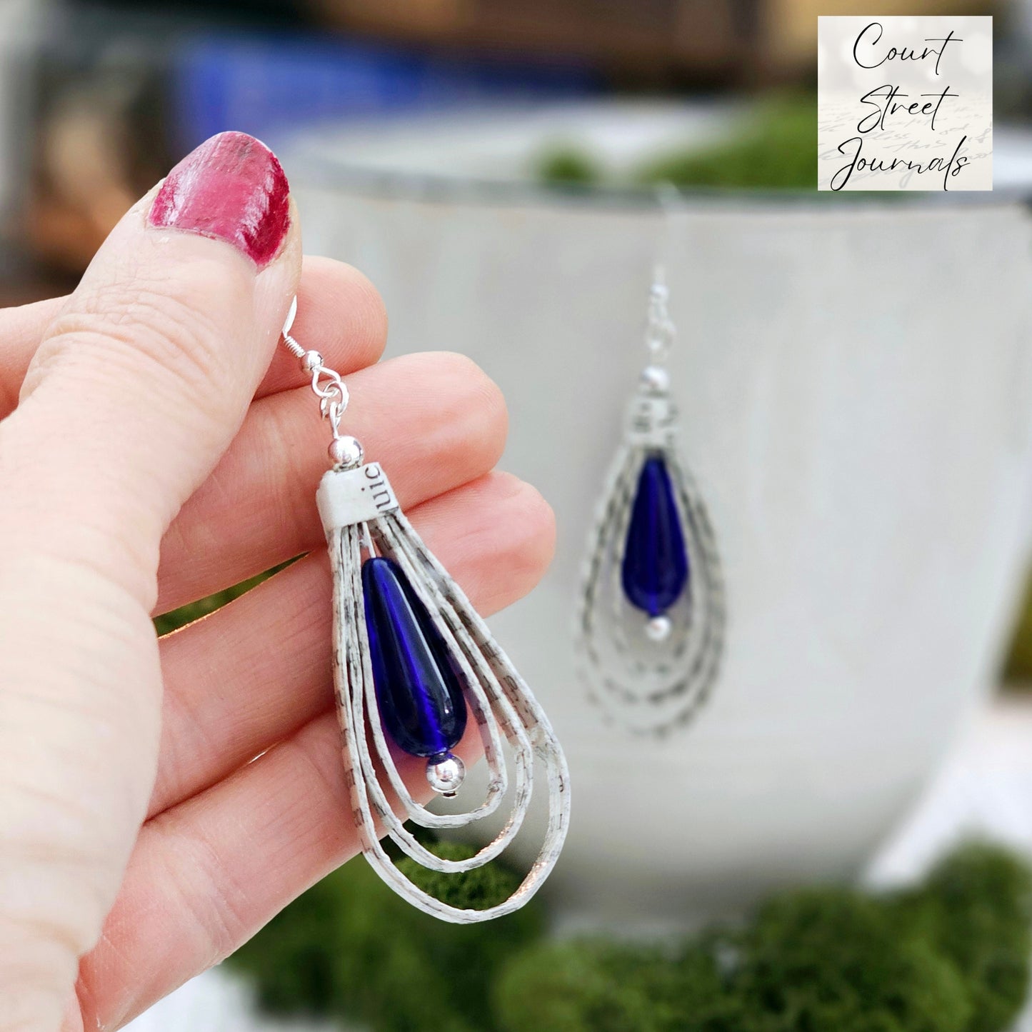 Tear Drop dangle earrings made from upcycled book pages with a blue czech glass tear drop bead accent. earring is 2.5 inches long. Sterling silver ear wire.