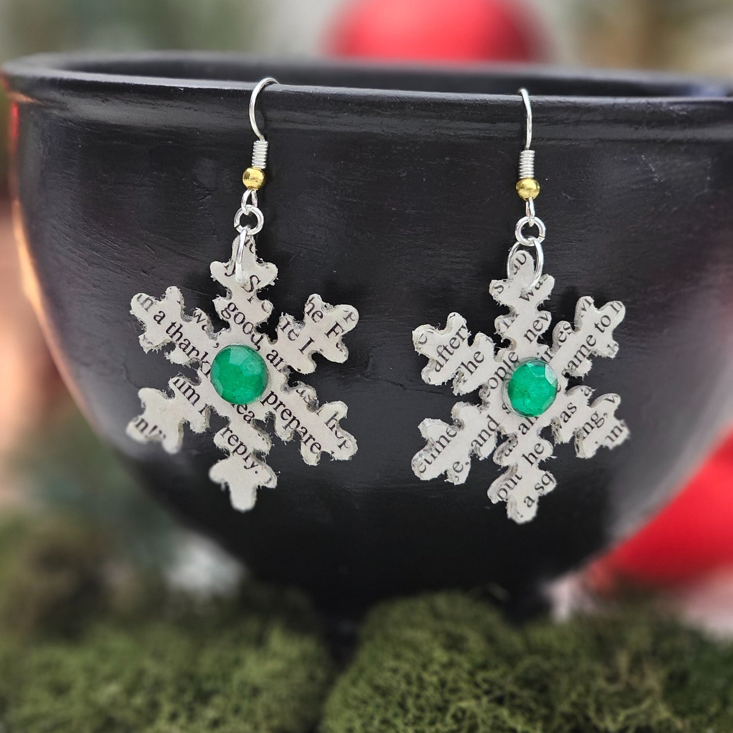 Snow flake dangle earrings made from book pages, they come ready to gift in a book page envelope. Earrings measure 1.5x1.5 inches and have a green acrylic accent on each side of the snowflakes.