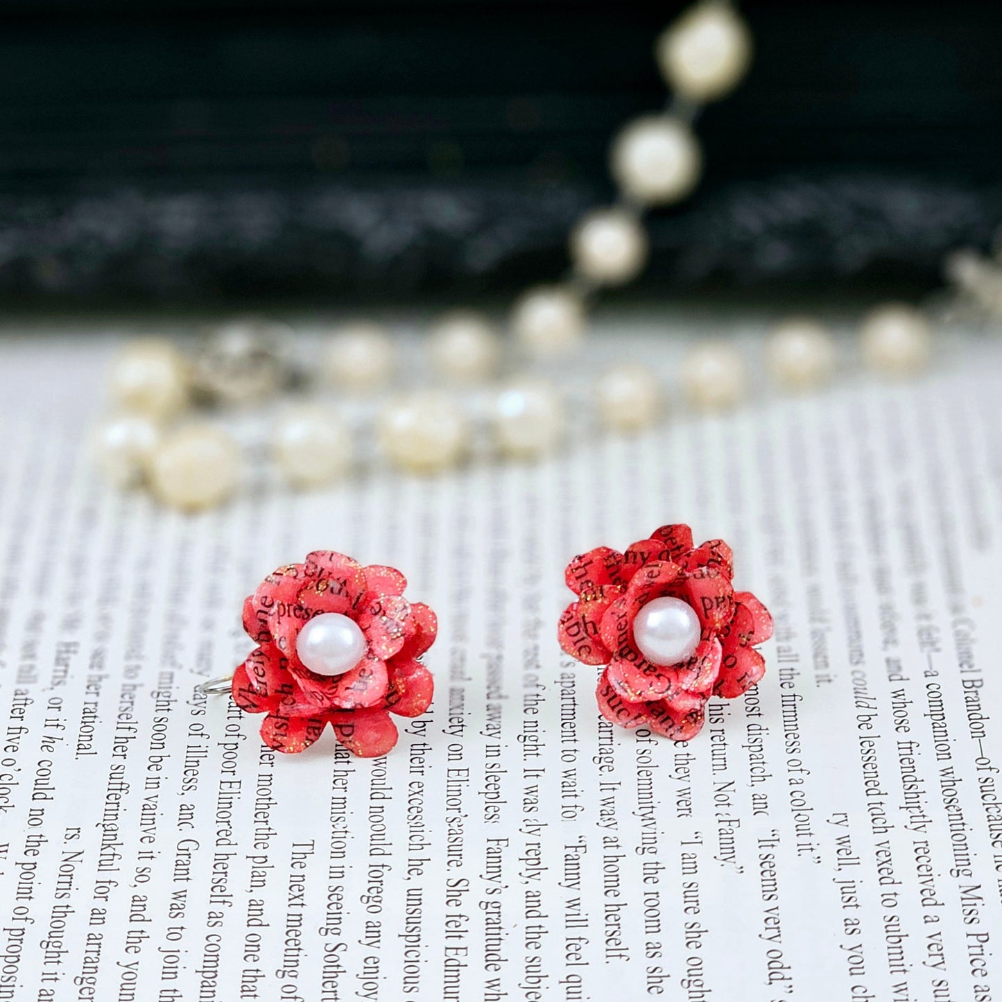 Red Rose Book Page Earrings, Drop Ear Wire made of stainless steel. The center of the rose has a whie acrylic accent. Each pair comes in a gift box adorned with 3 paper roses.