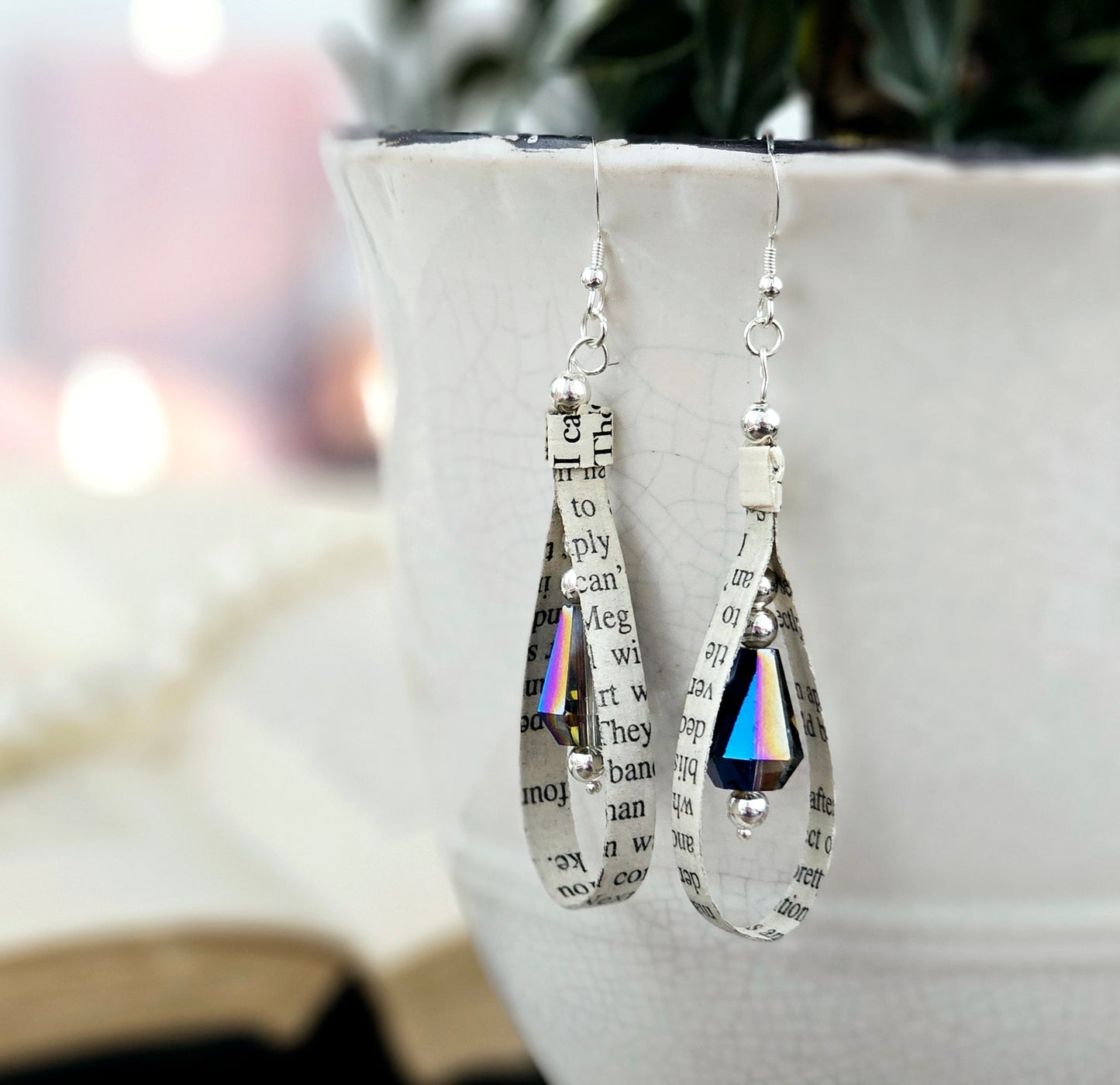Tear drop shaped earrings made from book pages with blue faceted accent bead.