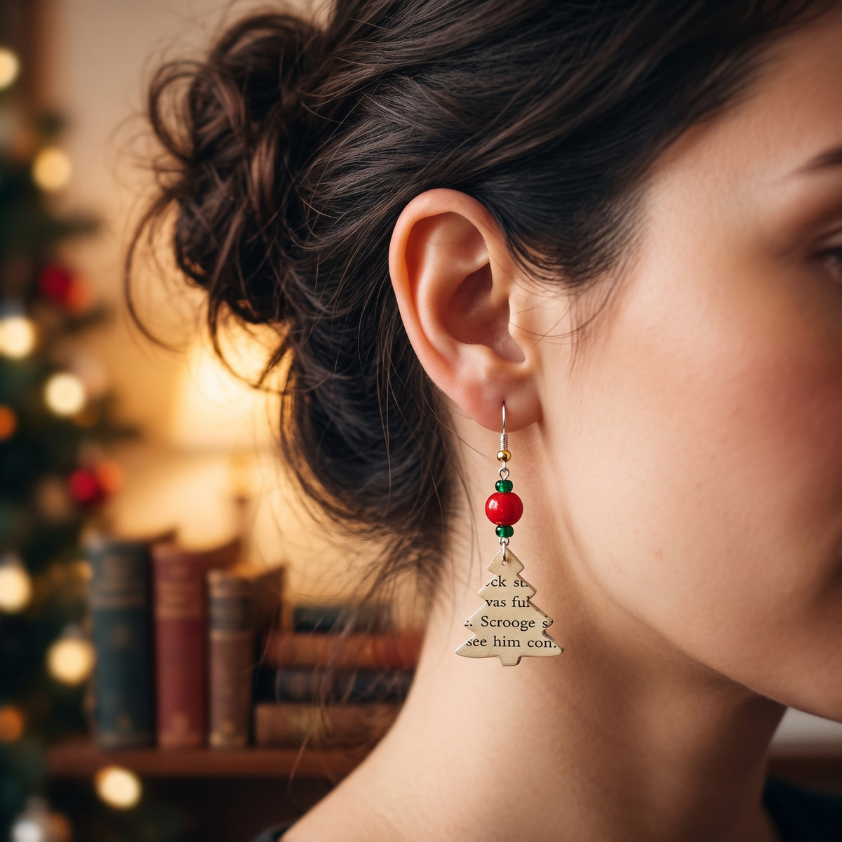 modeled photo of christmas tree earrings made from the pages of a Christmas Carol