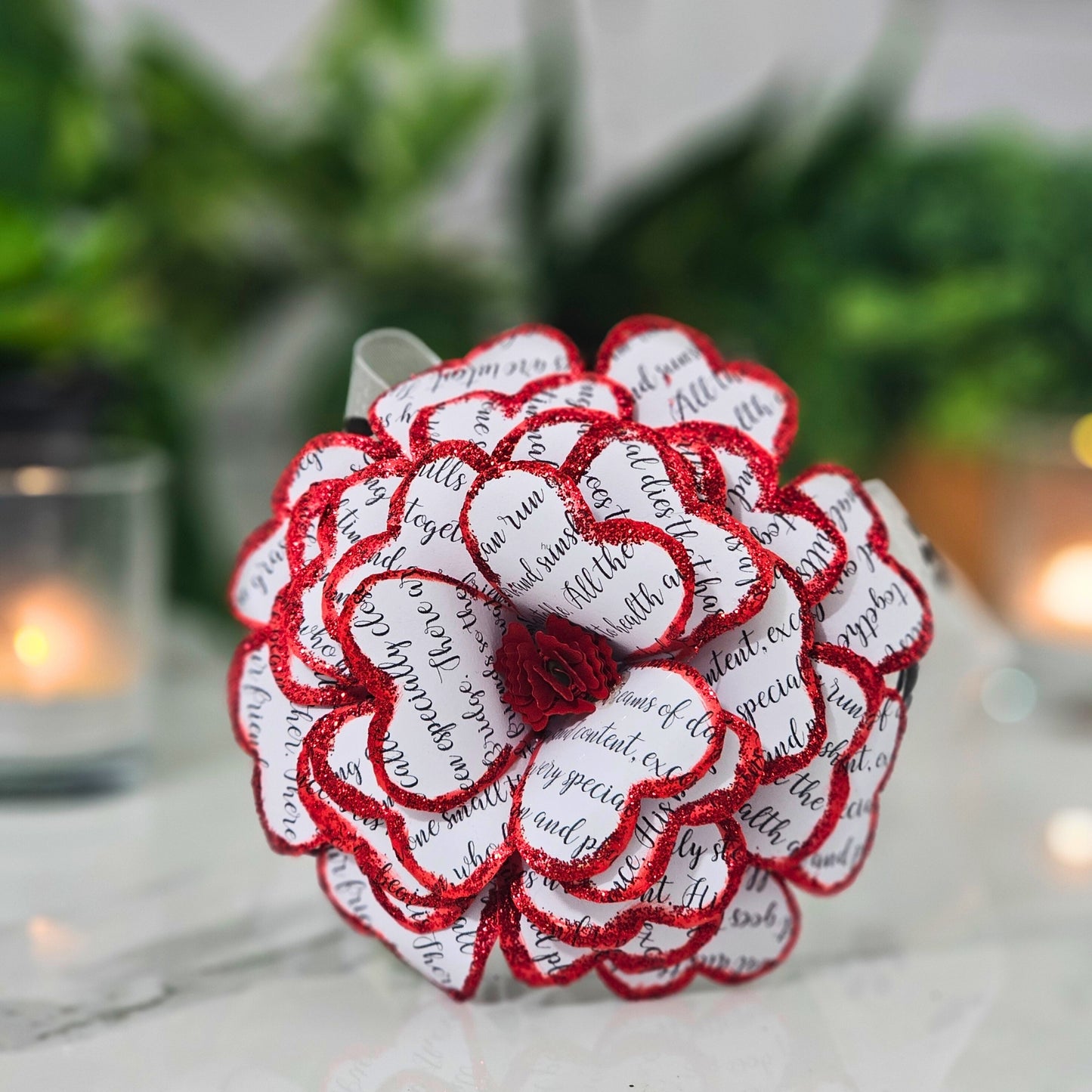 Close-up detail of handcrafted red rose made from upcycled book pages"