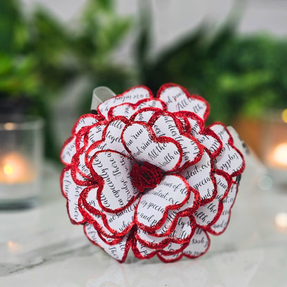 Close-up detail of handcrafted red rose made from upcycled book pages"
