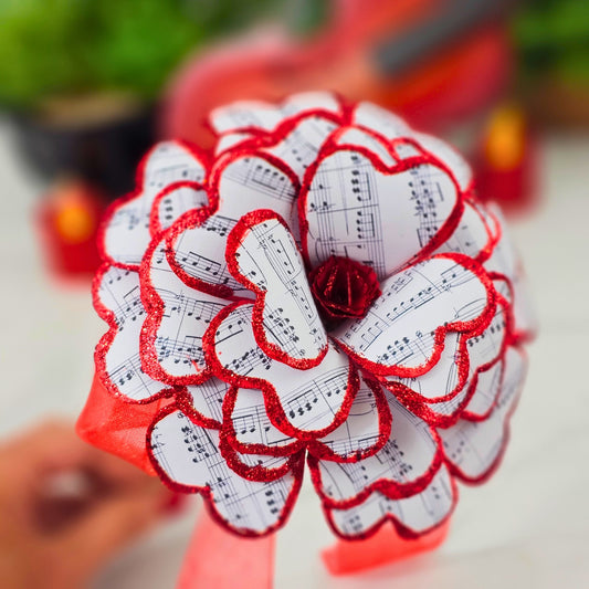 Red sheet music paper rose close-up showing hand-stained petals and sparkle detail