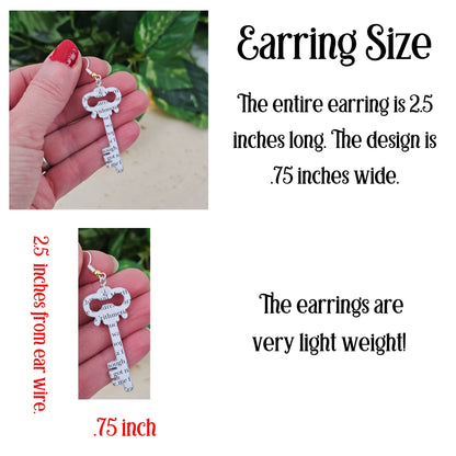 Key-shaped earring held by a hand with text providing dimensions and weight information.