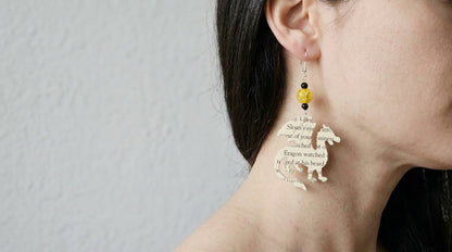 modeled shot of book page dragon earrings