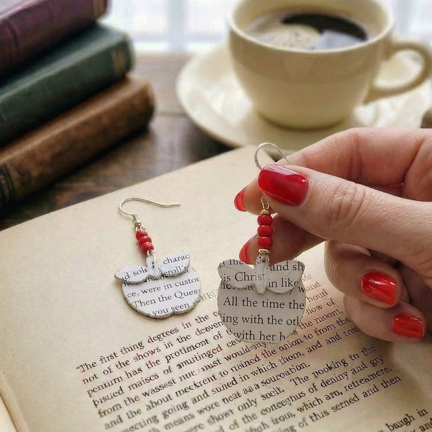 handheld picture of apple book page earrings

