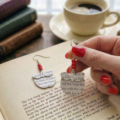 handheld picture of apple book page earrings
