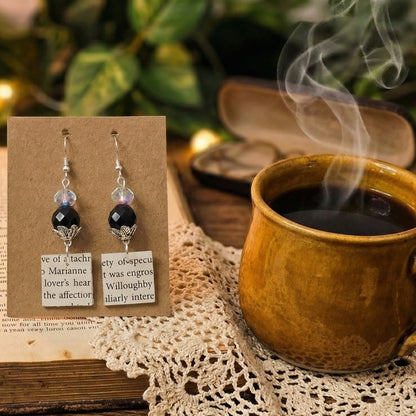 close up shot of book page earrings, square book page cuts with 2 blass bead accents, sterling silver ear wires