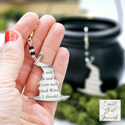 Close-up of witch hat earrings showing  book page text and glass seed bead detail