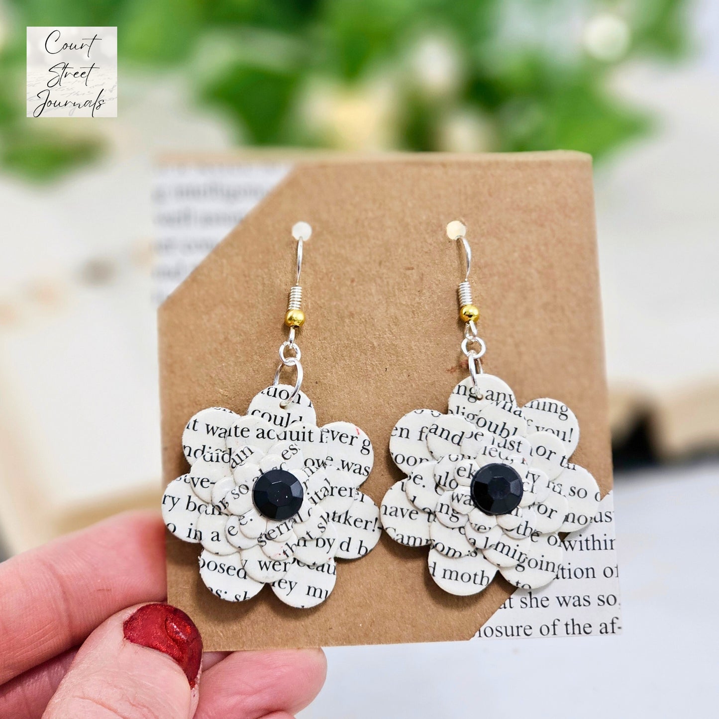 close up view of book page dangle earrings 