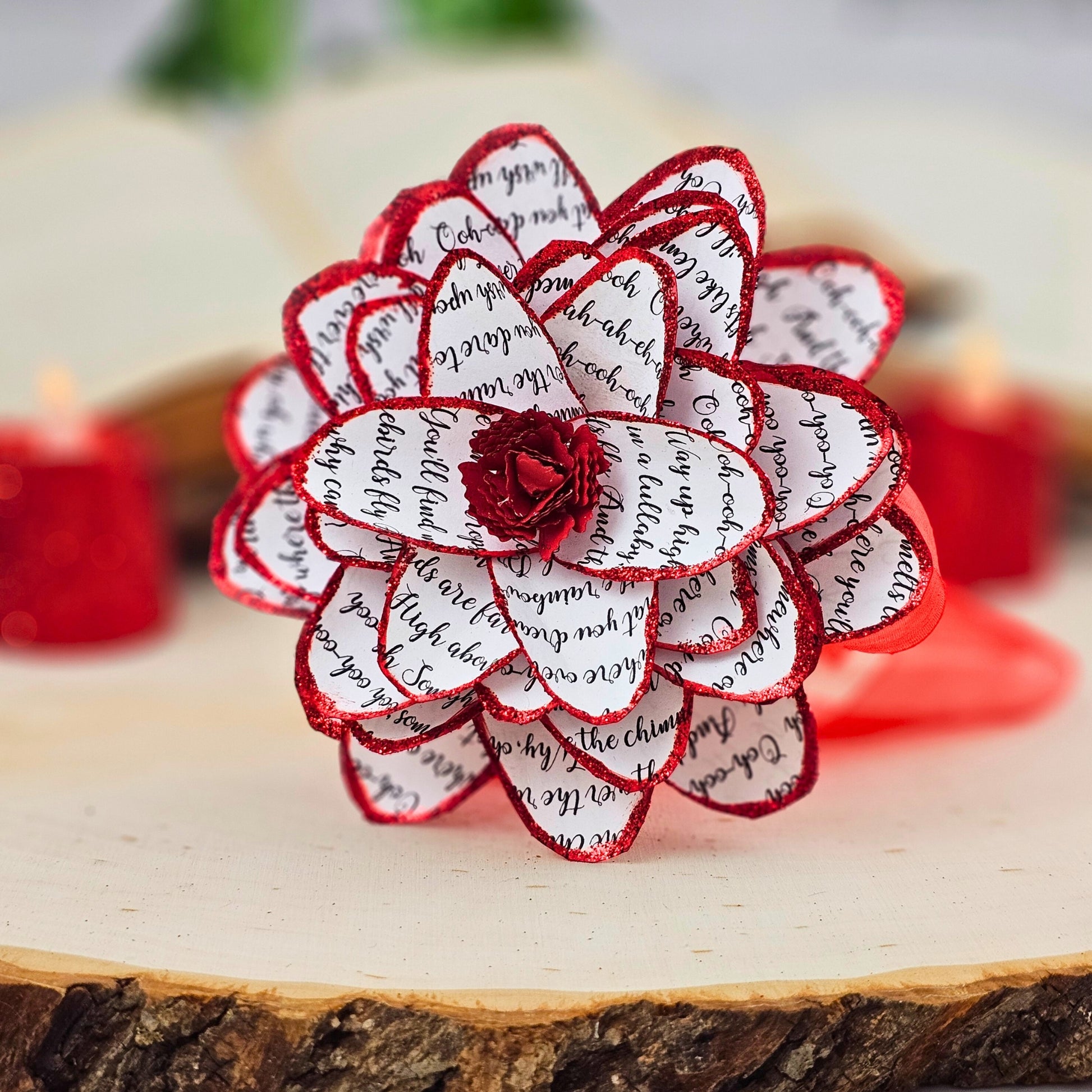 close up of handmade paper dahlia flower with song lyrics printed on it.