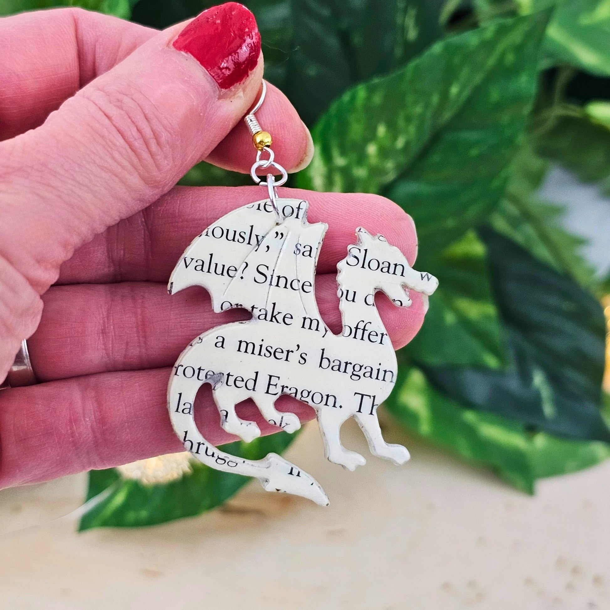 close up of book page dragon earrings; jewelry for fantasy book lovers
