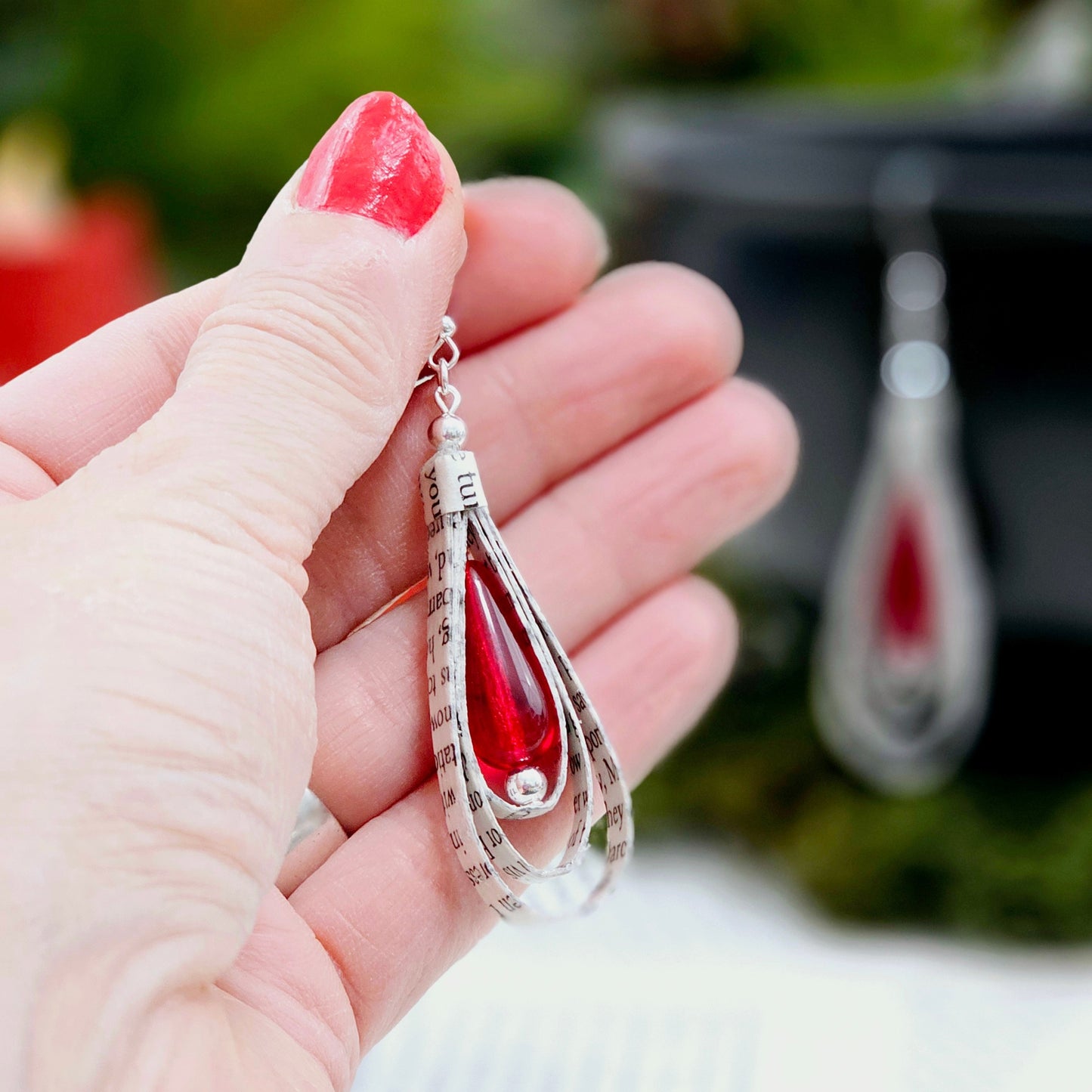 Close-up of handmade book page dangle earrings showing text detail