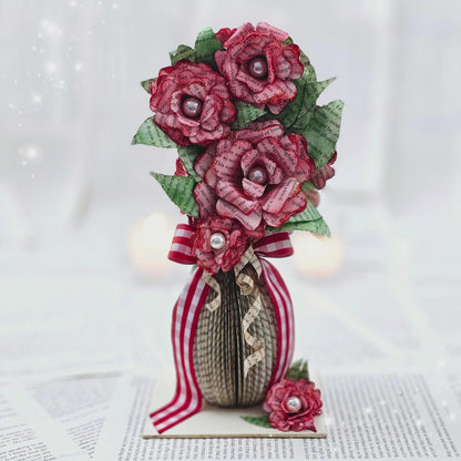 9 inch tall book page flower bouquet, the roses are stained red.  The vase is made from book pages .  The entire piece sits on a base made from the book cover.