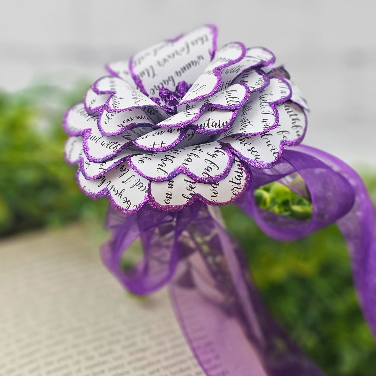 Decorative flower made of paper with purple accents on a blurred natural background