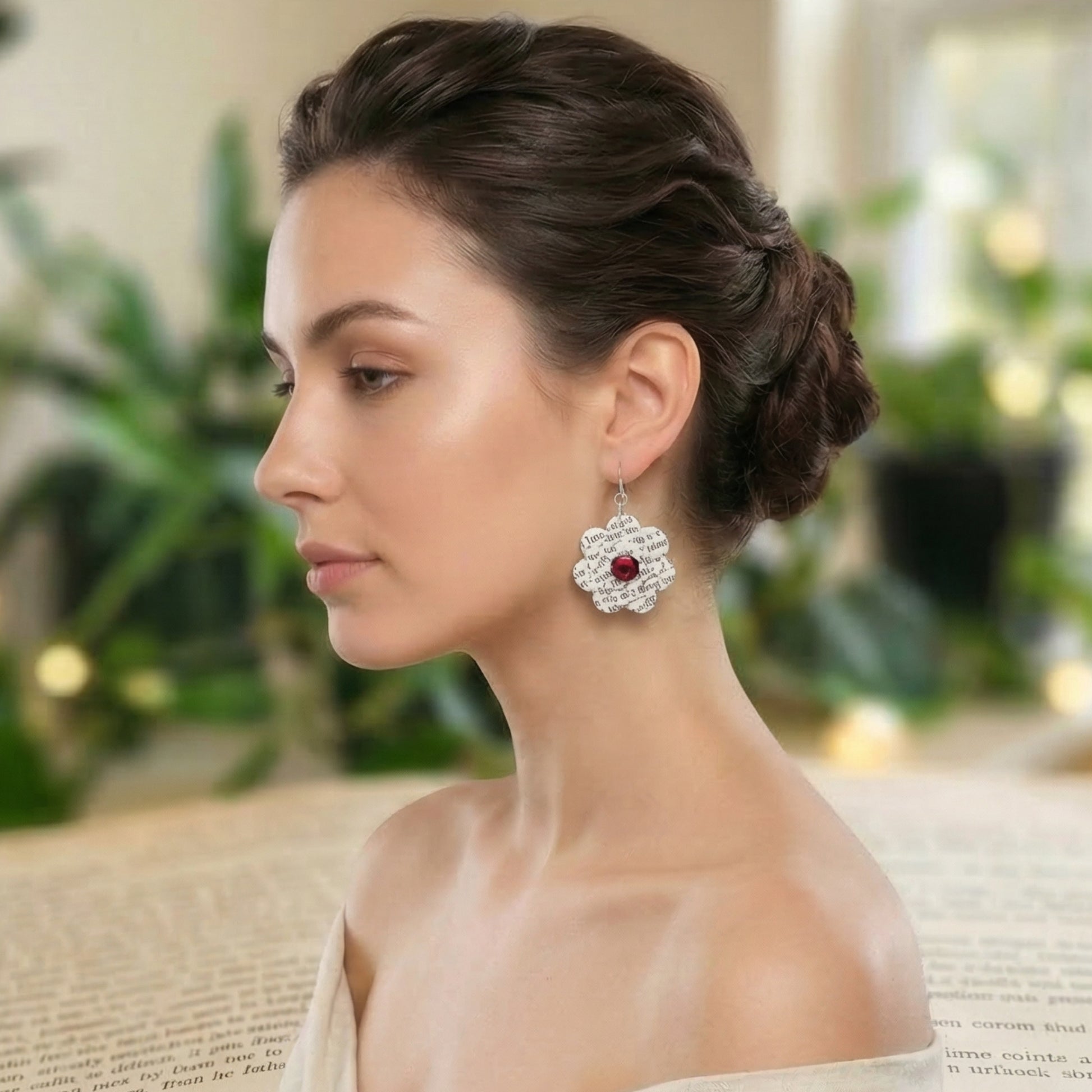book page earrings in the shape of a flower, several layers of dimension, with a red acrylic cabachon on both sides of the earring